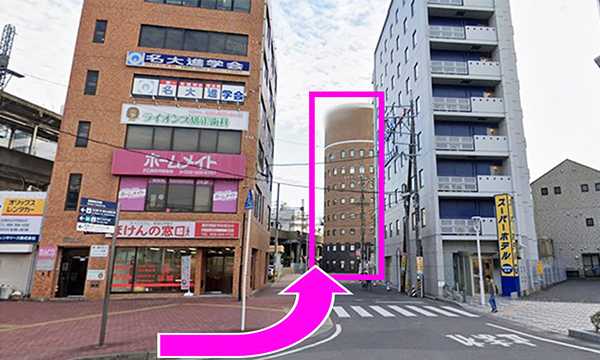 ほけんの窓口とスーパーホテルの間の道をまっすぐ進みます（正面の茶色い建物がお店の入っているところです）